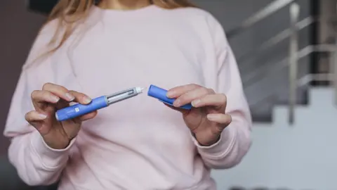 Getty Images Semaglutide pen preparation for injection therapy captured in detail. The image depicts a medical device essential for individuals managing weight loss or type 2 diabetes.
